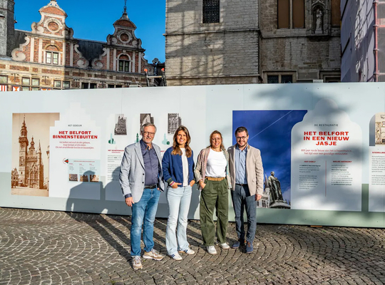 Gedeputeerde Coppens, met schepen Blommaert, schepen De Meerleer en schepen Smeyers aan het belfort